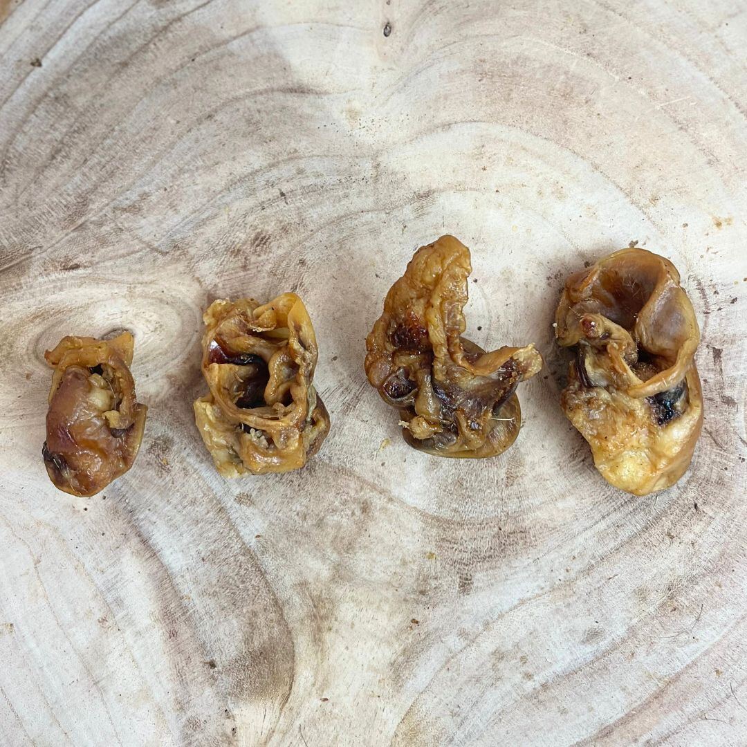 Selection of loose natural dog treats laid out on a wooden board